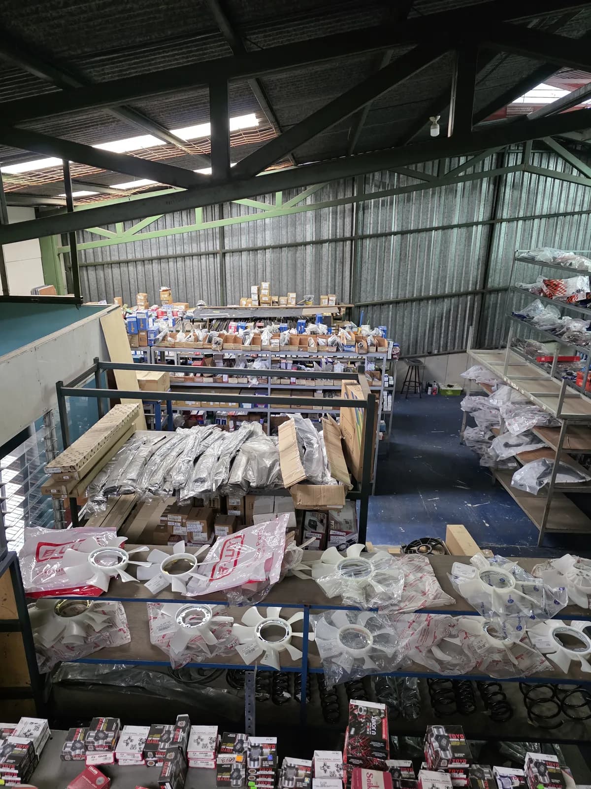 Pasillo de bodega con repuestos organizados por categoría